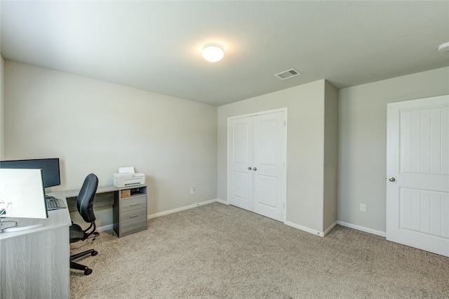 office area featuring visible vents, baseboards, and light colored carpet