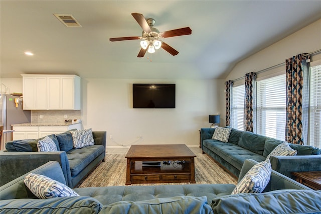 living room featuring visible vents, ceiling fan, baseboards, and lofted ceiling