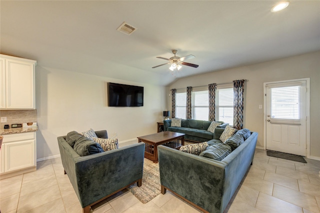 living room featuring visible vents, light tile patterned floors, baseboards, ceiling fan, and vaulted ceiling