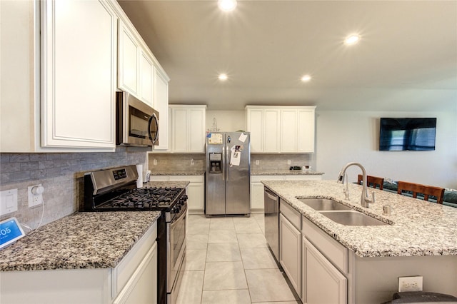 kitchen featuring recessed lighting, a kitchen island with sink, light tile patterned flooring, a sink, and stainless steel appliances