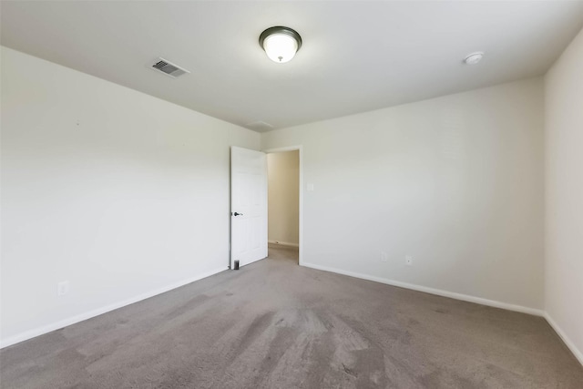 carpeted empty room featuring baseboards and visible vents