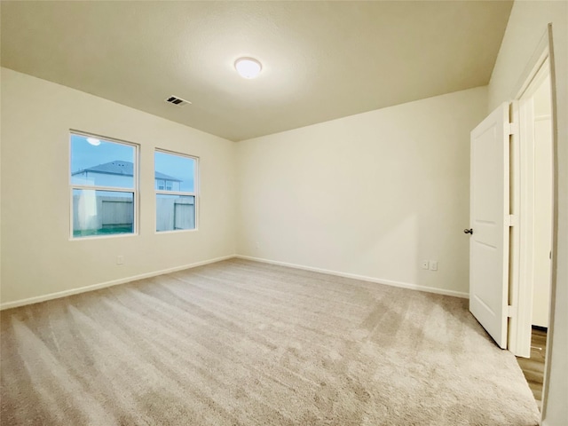 unfurnished room featuring light colored carpet, baseboards, and visible vents