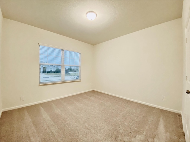carpeted empty room with baseboards