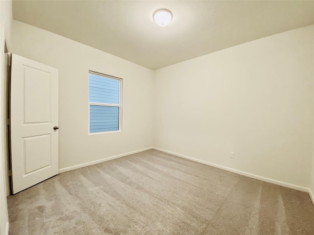 carpeted empty room with baseboards