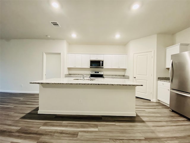 kitchen with wood finished floors, white cabinetry, visible vents, and stainless steel appliances