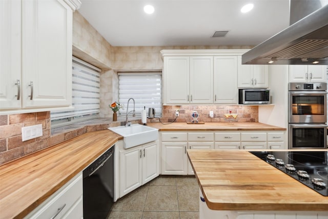 12538 W Pavilion Ct W, Tomball, TX 77377 - kitchen with butcher block countertops, black appliances, a sink, wall chimney exhaust hood, and recessed lighting