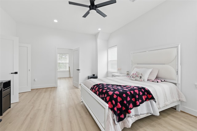 bedroom featuring light wood finished floors, baseboards, vaulted ceiling, and recessed lighting
