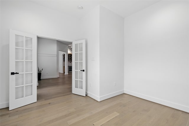 unfurnished room with french doors, baseboards, and wood finished floors