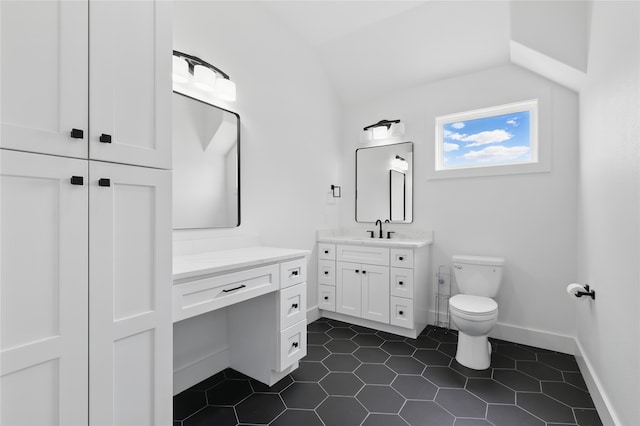 bathroom with baseboards, toilet, vanity, tile patterned flooring, and lofted ceiling