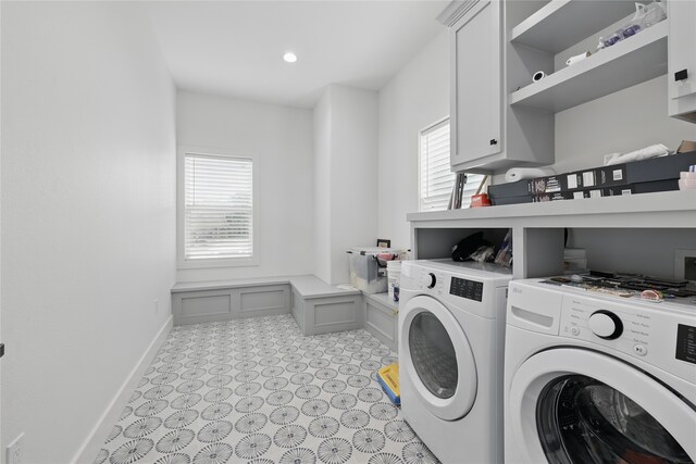 laundry area featuring plenty of natural light, washer and clothes dryer, baseboards, and cabinet space