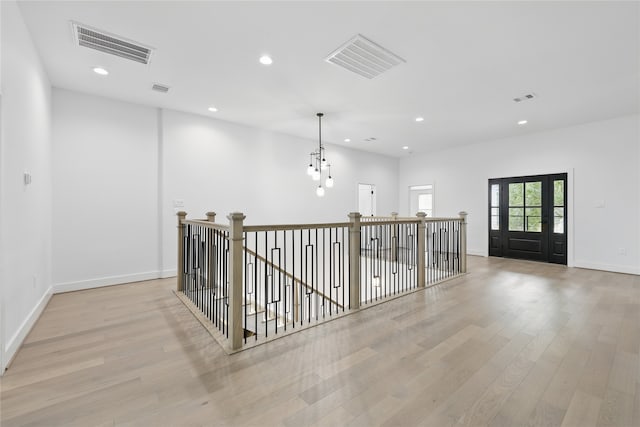 hall featuring light wood-type flooring, visible vents, and recessed lighting