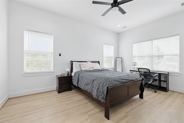 bedroom with light wood-type flooring, visible vents, and multiple windows