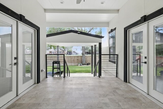 doorway with beam ceiling, ceiling fan, and plenty of natural light