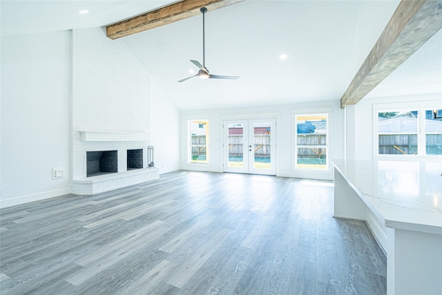 8006 17th Green Dr, Humble, TX 77346 - unfurnished living room with baseboards, a fireplace, beamed ceiling, ceiling fan, and wood finished floors