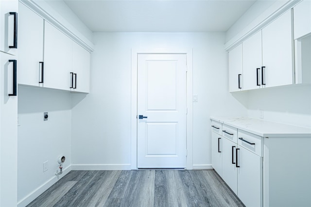 8006 17th Green Dr, Humble, TX 77346 - laundry area featuring light wood-style flooring, baseboards, cabinet space, and electric dryer hookup