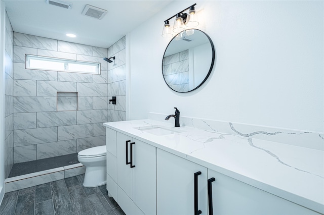 8006 17th Green Dr, Humble, TX 77346 - bathroom featuring vanity, visible vents, a tile shower, and toilet