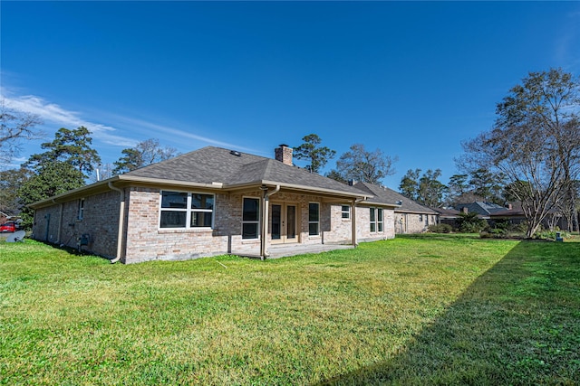 8006 17th Green Dr, Humble, TX 77346 - back of house featuring a patio, a chimney, brick siding, a yard, and a shingled roof