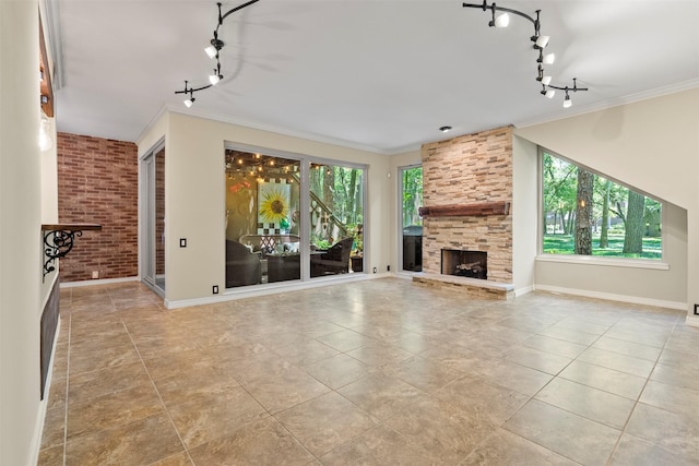 53 Litchfield Ln, Houston, TX 77024 - unfurnished living room featuring rail lighting, tile patterned flooring, ornamental molding, a stone fireplace, and baseboards