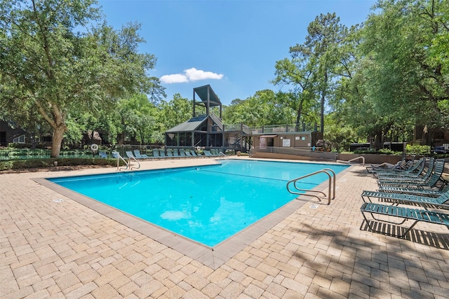 53 Litchfield Ln, Houston, TX 77024 - community pool featuring a patio area, view of scattered trees, and fence