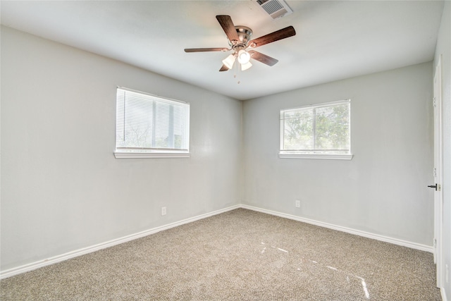 carpeted empty room featuring baseboards, a ceiling fan, and visible vents