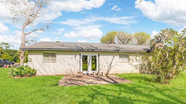rear view of house featuring a patio, a yard, and french doors