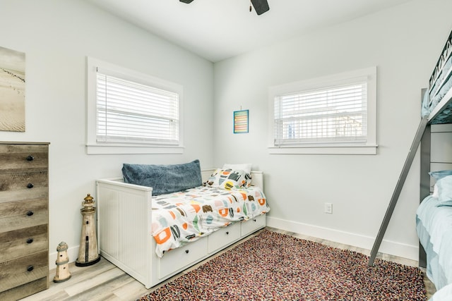 bedroom featuring ceiling fan, baseboards, and wood finished floors