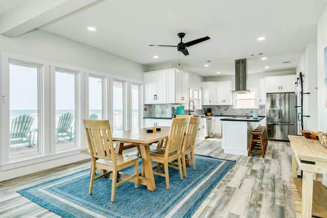 dining space featuring visible vents, ceiling fan, light wood finished floors, and plenty of natural light