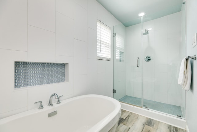 bathroom featuring a freestanding bath, a stall shower, and wood finished floors