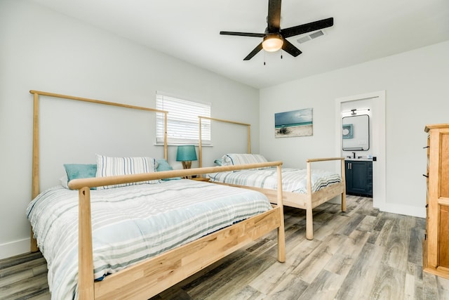 bedroom featuring visible vents, baseboards, a ceiling fan, and light wood-style flooring