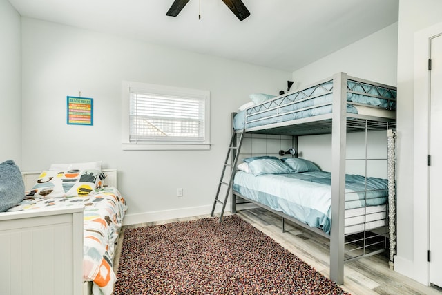 bedroom with baseboards, ceiling fan, and wood finished floors