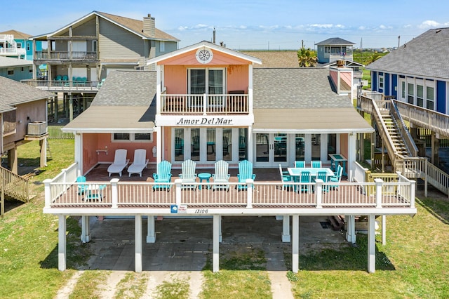 back of property featuring a lawn, a carport, driveway, and a shingled roof