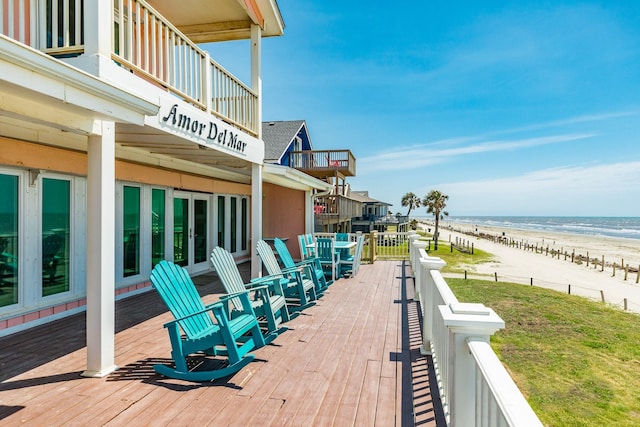 exterior space featuring a water view, french doors, a view of the beach, and a balcony