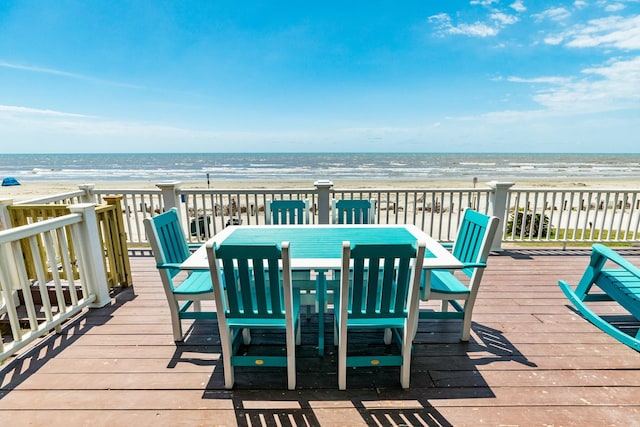 wooden deck with a water view and a view of the beach