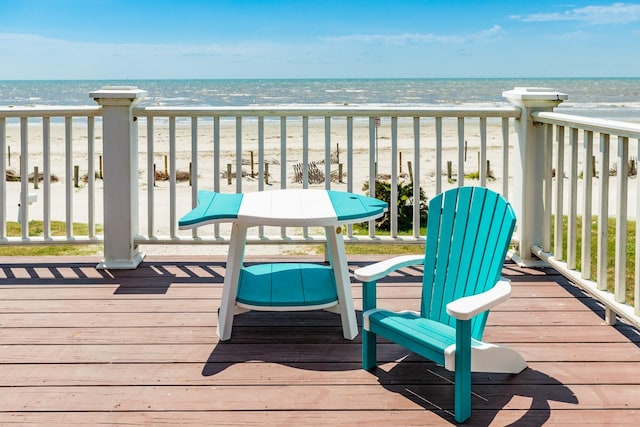 wooden deck with a water view and a view of the beach