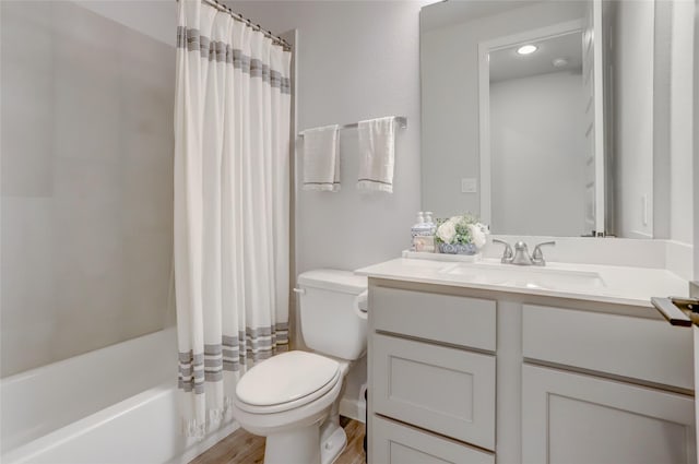 full bathroom with toilet, shower / bath combo, wood finished floors, and vanity
