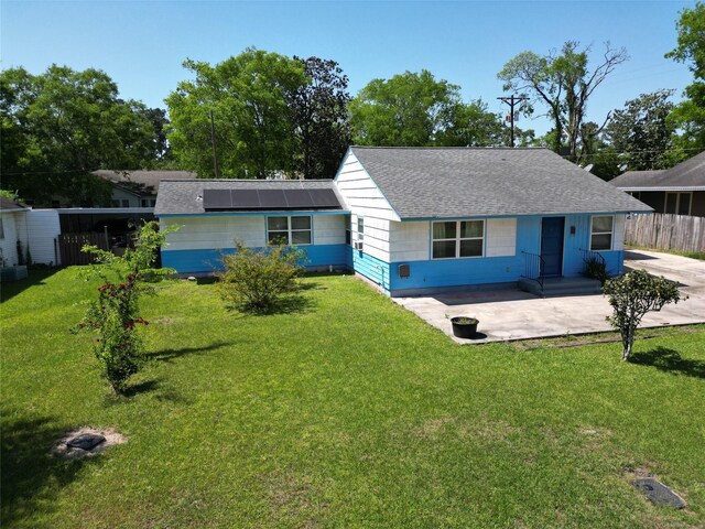 106 Jordan Ave, Cleveland, TX 77327 - view of front of home featuring a front yard, fence, a shingled roof, and solar panels