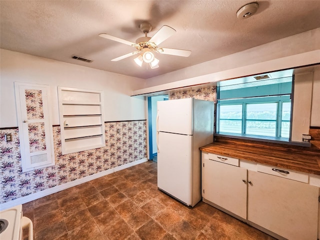106 Jordan Ave, Cleveland, TX 77327 - kitchen with visible vents, baseboards, ceiling fan, freestanding refrigerator, and wallpapered walls