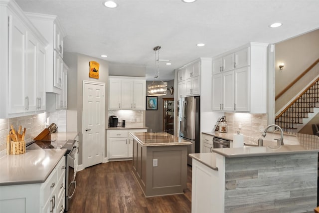 14832 Oak Shores Dr, Willis, TX 77318 - kitchen featuring stainless steel appliances, backsplash, a peninsula, dark wood-type flooring, and recessed lighting