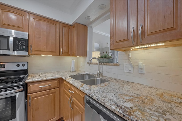 kitchen featuring tasteful backsplash, a sink, crown molding, and appliances with stainless steel finishes