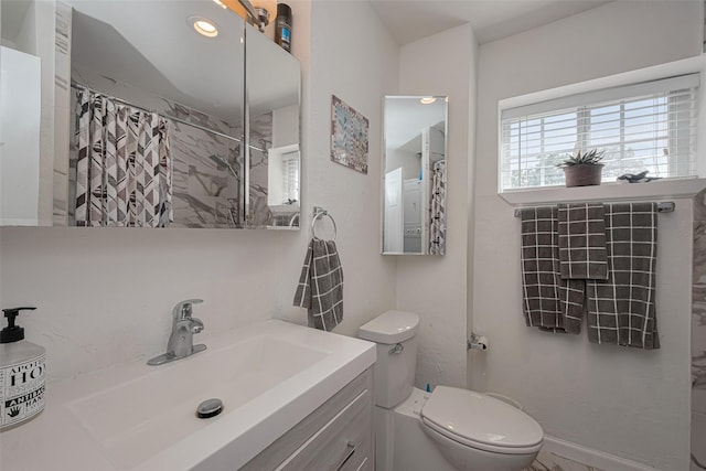 bathroom with curtained shower, vanity, and toilet