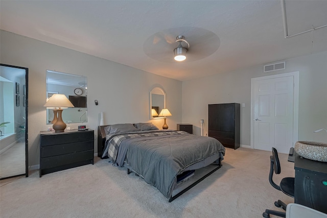 bedroom with visible vents, baseboards, ceiling fan, attic access, and light colored carpet