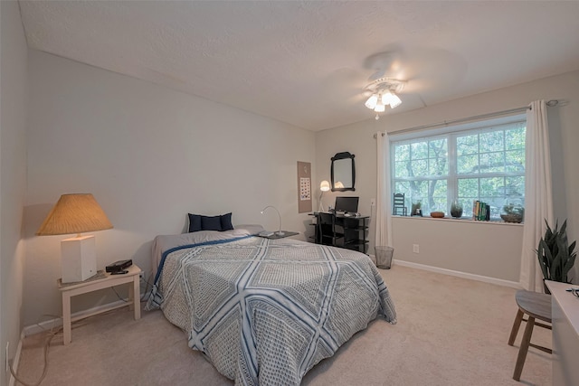 bedroom with light carpet, baseboards, and a ceiling fan