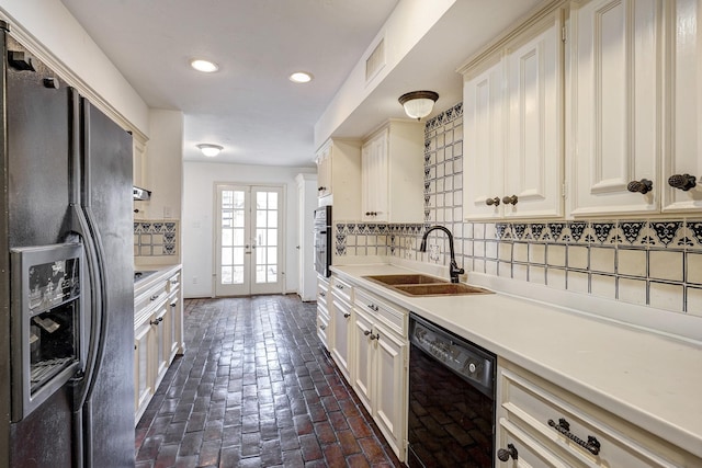 7628 Del Monte Dr, Houston, TX 77063 - kitchen with tasteful backsplash, a sink, light countertops, brick floor, and black appliances