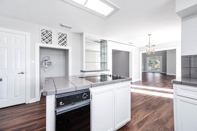 kitchen with a chandelier, visible vents, dark wood finished floors, and black appliances
