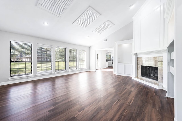 unfurnished living room featuring baseboards, a tiled fireplace, dark wood finished floors, and visible vents