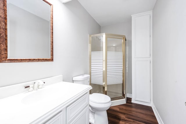 full bathroom featuring toilet, a stall shower, wood finished floors, and vanity