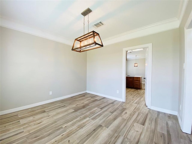 empty room with light wood-style floors, baseboards, ornamental molding, and visible vents