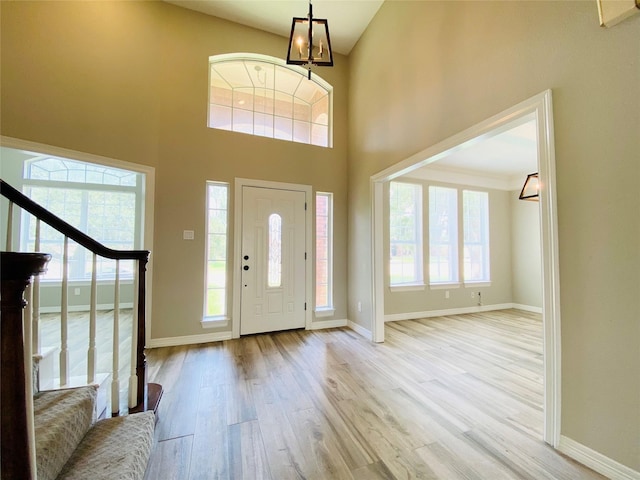 entryway featuring baseboards, plenty of natural light, wood finished floors, and stairs