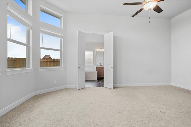 unfurnished bedroom featuring baseboards, a ceiling fan, carpet, and connected bathroom
