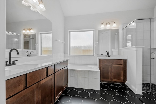 full bath with two vanities, a sink, a stall shower, tile patterned floors, and a garden tub